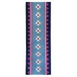 Blue runner rug handwoven from New Zealand wool with a geometric design of star motifs and a pink zig zag border inspired by Victorian tiles.