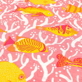 Detail of the pink coral reef baby quilt handprinted with tropical fish in colourful shades of pink, yellow and orange.