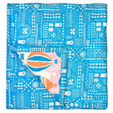 The other side of the Balloons at Dawn baby quilt which has a bright blue geometric print pattern.
