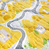 Detail of the cave house baby quilt handprinted in yellow and grey onto soft cotton.