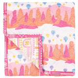 Fairy Chimney Baby Quilt handprinted with an illustrated landscape of hot air balloons in a pretty palette of pink orange and yellow.