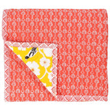 The reverse of the Yellow Weaver baby quilt handprinted with a coral red floral motif pattern inspired by hibiscus flowers.