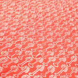 Detail of the coral red reverse of the yellow weaver baby quilt handprinted with a hibiscus flower motif.