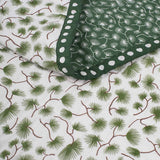 Close up of the Green Pine Baby Quilt hand printed and hand quilted from soft cotton with a playful dot print edge.