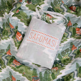 The Mountain Zig Zag baby quilt in a cotton bag embroidered with the Safomasi logo.