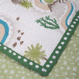 Corner detail of Winding Roads Baby Quilt featuring palm trees, cacti and dot print border in natural tones of green, blue and taupe brown.